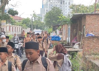 Siswa MTSN 2 Medan saat pulang sekolah di Jalan Peratun Desa Medan Estate. (Dok.ABC)